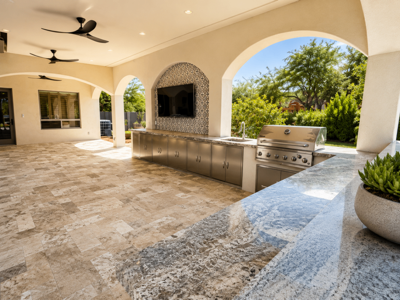 Wood Street covered patio with stone counters, outdoor kitchen, and tiled media wall