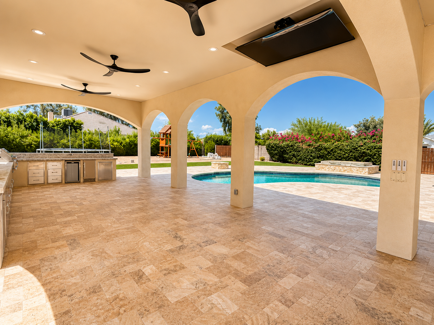 Wood Street covered patio with travertine floors, arched openings, and pool view