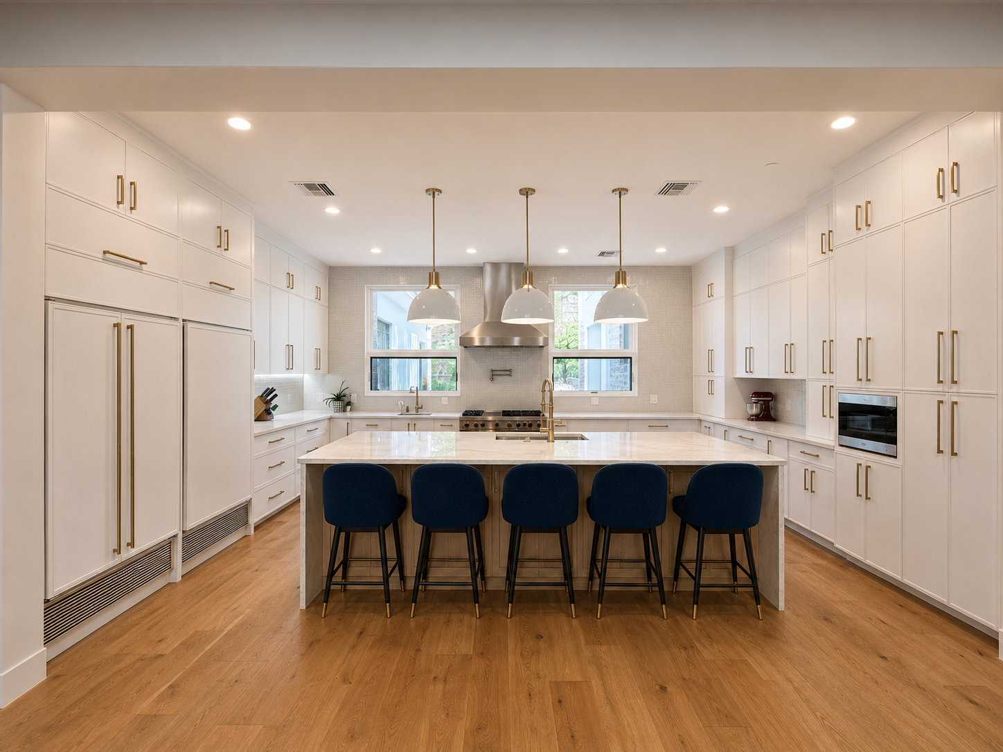 Cheney kitchen wide view with white cabinetry, brass hardware, and range wall