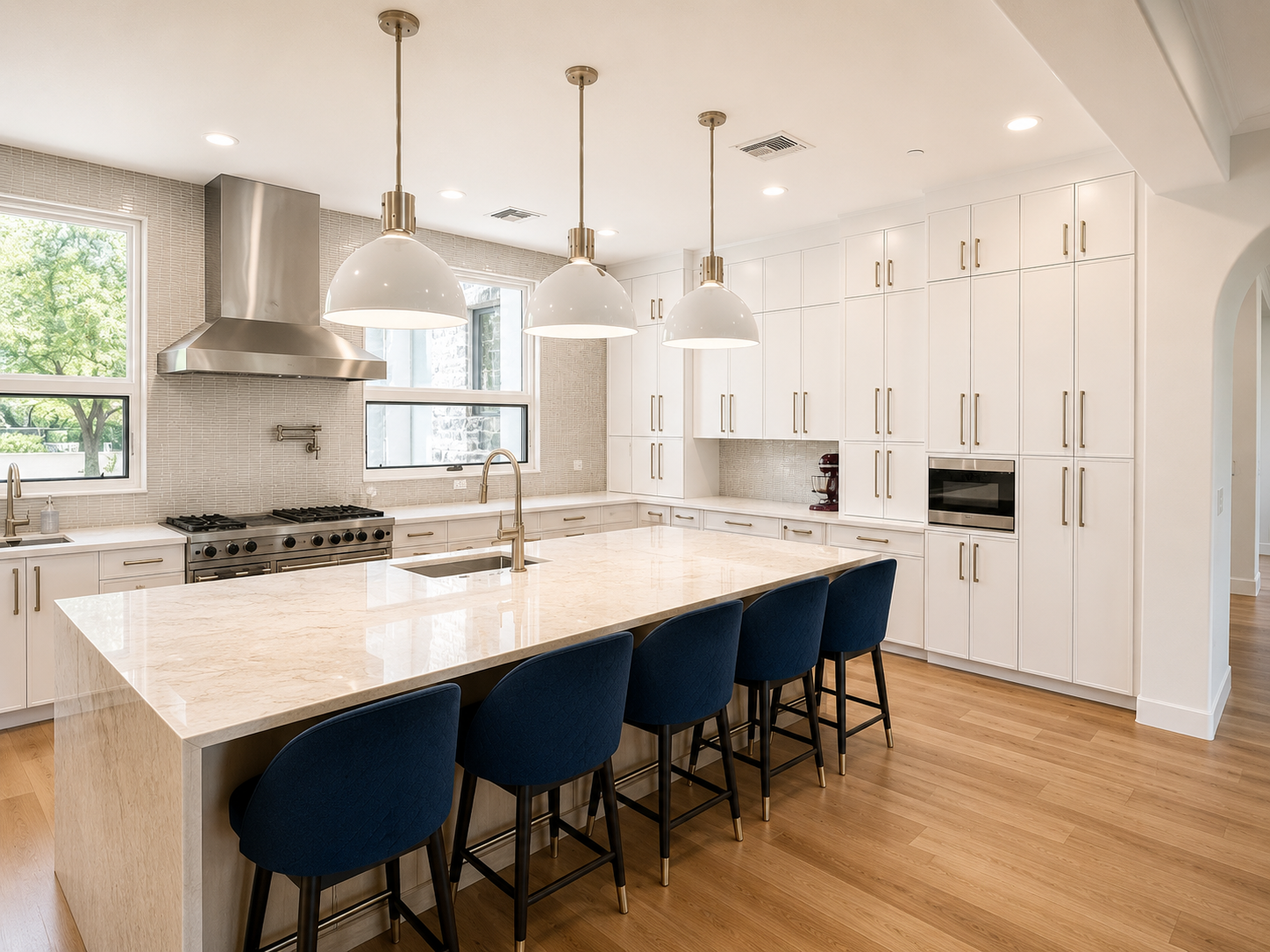 Cheney kitchen with marble island, brass pendants, and navy counter stools